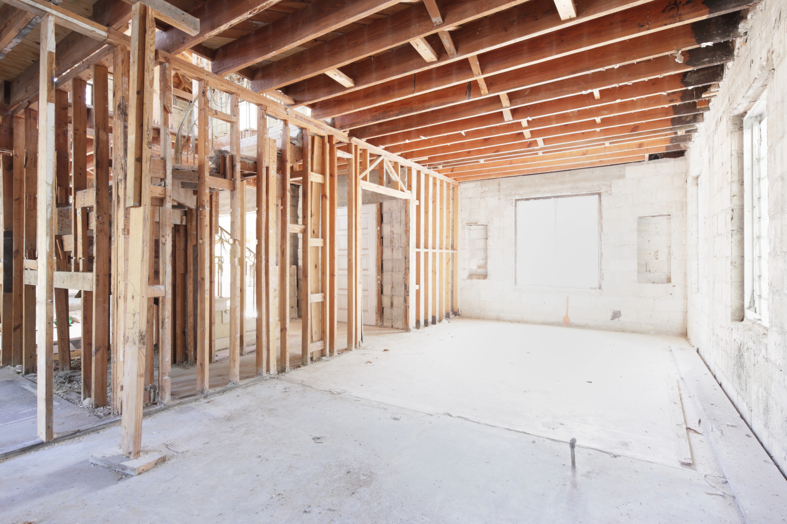 Crew performing interior demolition in a commercial building with debris cleared and walls exposed