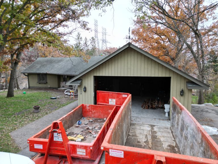 Interior demolition contractors in Lakeville are using a dumpster outside a home during a residential project